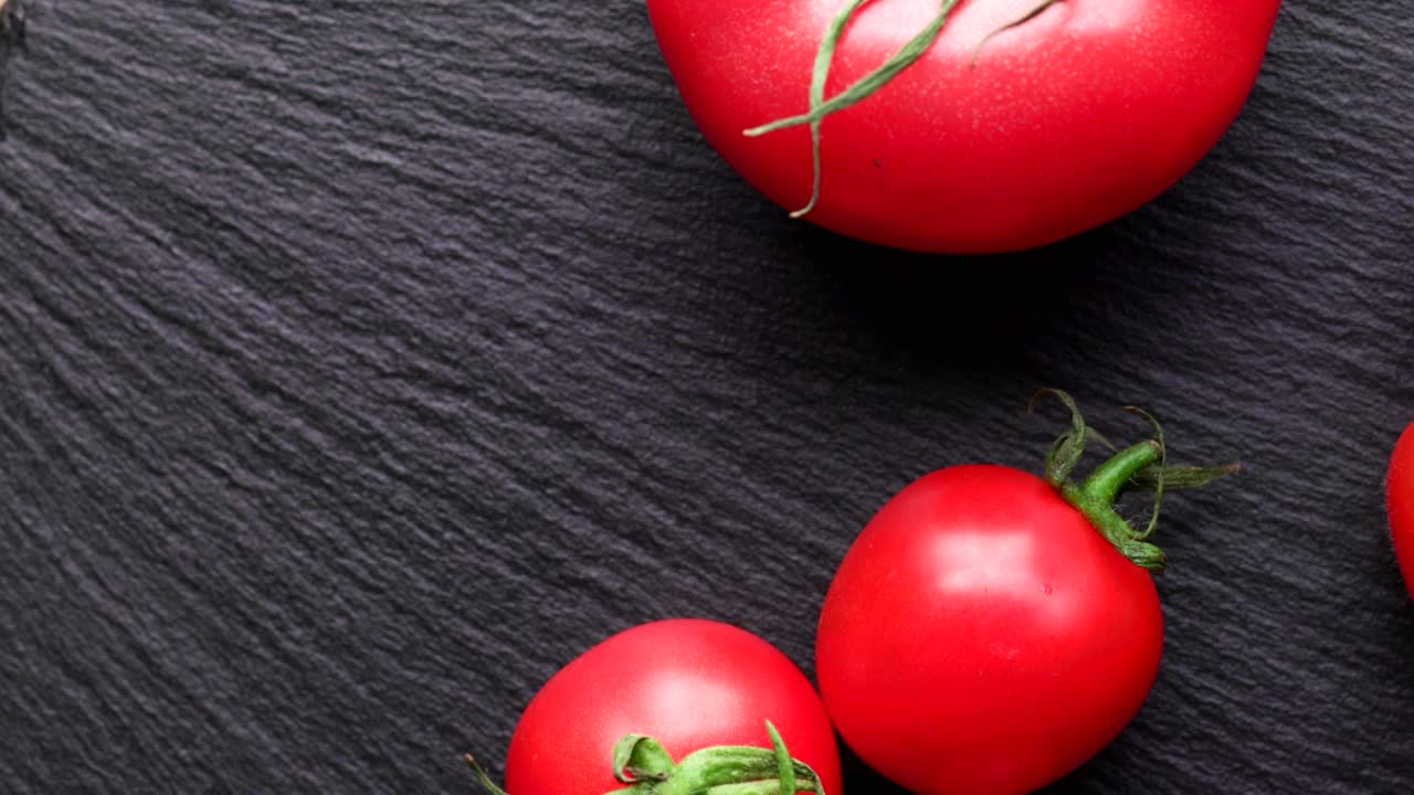 빨간 토마토가 위에서 검은 돌로 변하고 있습니다.