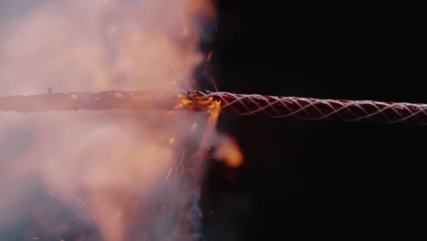 lit wick sparks with flames and smoke in darkness