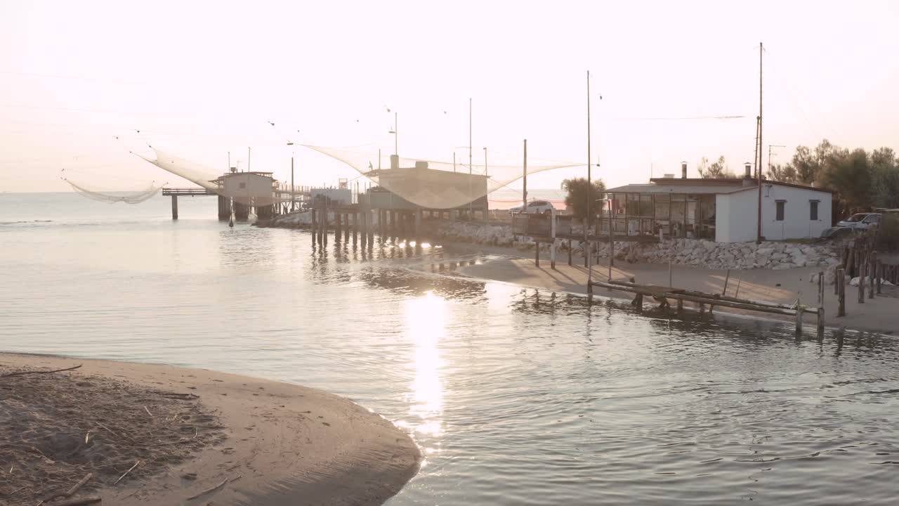 cabañas de pescadores con redes de pesca y equipos de pesca en el río por la mañana, lido di dante, fiumi uniti, ravenna cerca del valle de comacchio