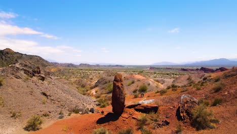 Drone-shot-flying-over-a-vertical-standing-rock-to-reveal-the-Reserva-Banda-Florida-in-La-Rioja,-Argentina