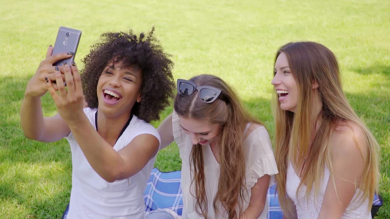 Happy women taking selfie in park