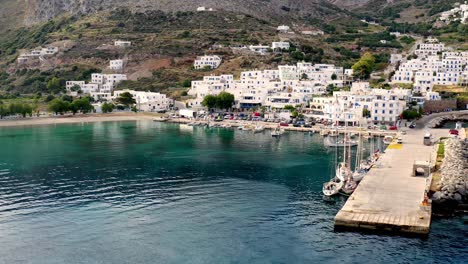 Port-Of-Aegiali-Aerial-View-Approaching-Village,-Hills-In-The-Background