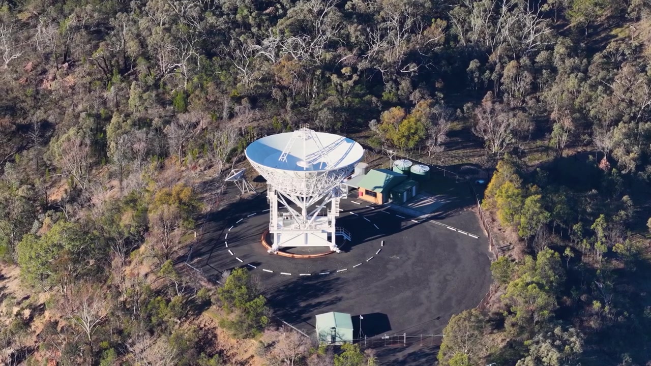 Vysokoúhlý záběr dronem bílého satelitního talíře v národním parku Warrumbungle v Austrálii