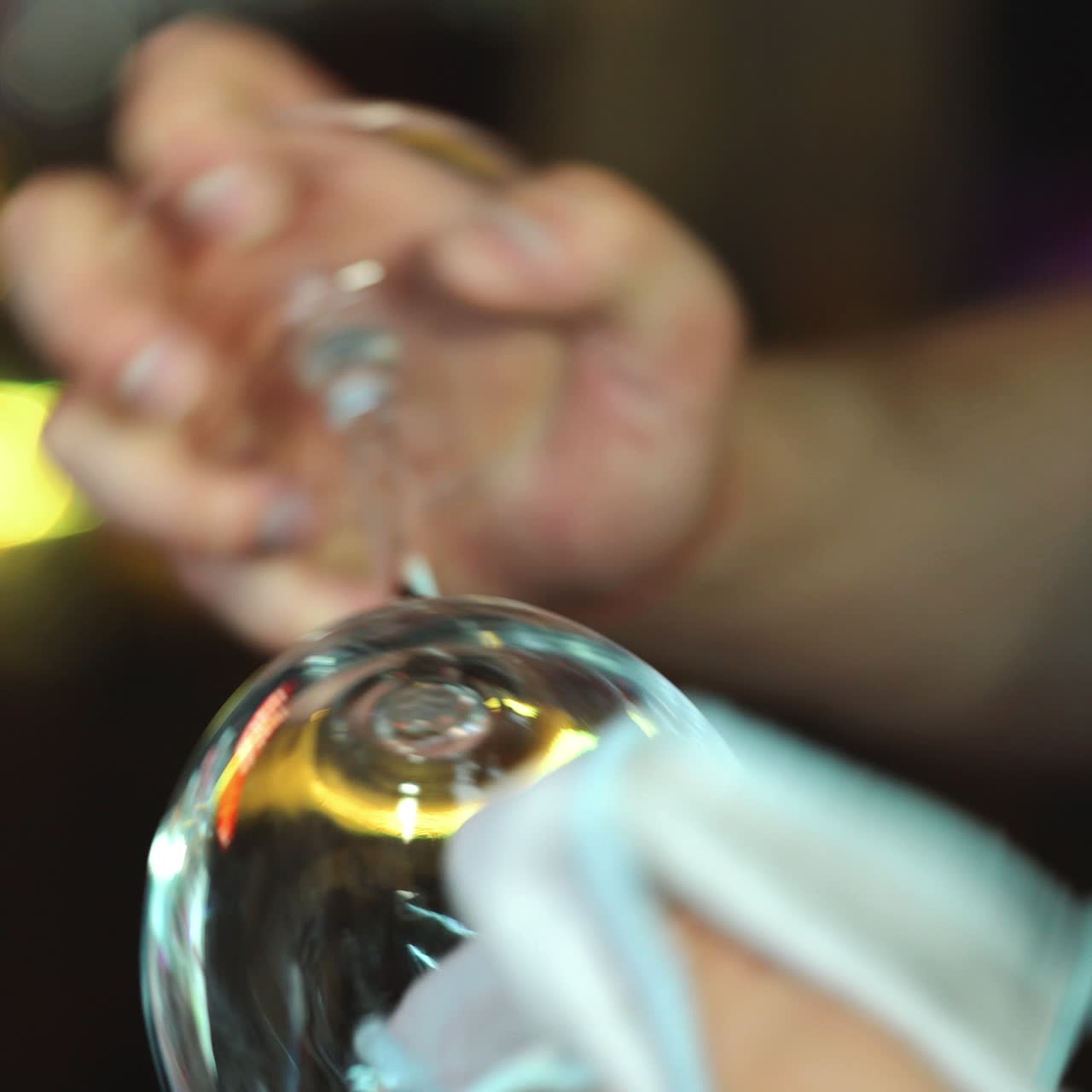 Bartender cleans the glass. Handsome bartender polishes a glass of wine glasses. Close up. Sqare video