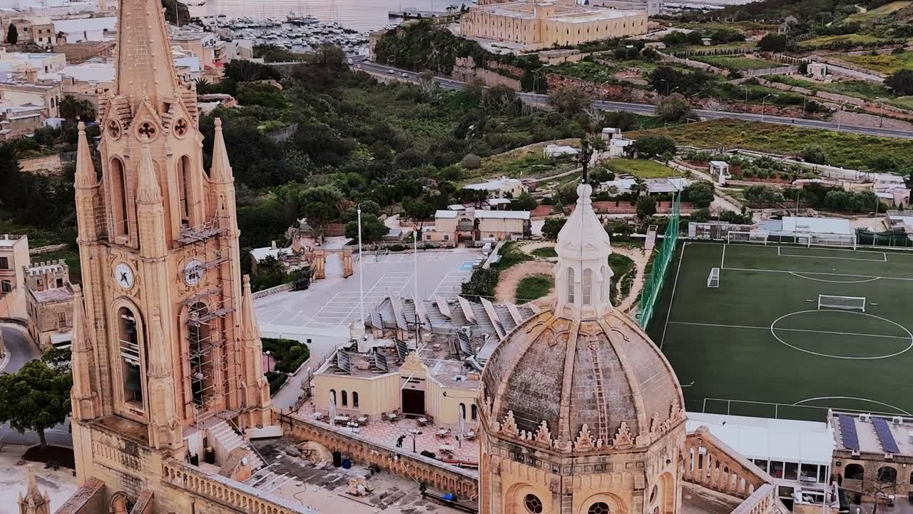 Panorami di Malta con campanile, campo verde e paesaggio costiero