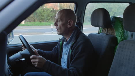 a mature frustrated man who is late for work is shouting and angry in his car whilst stuck in a traffic jam