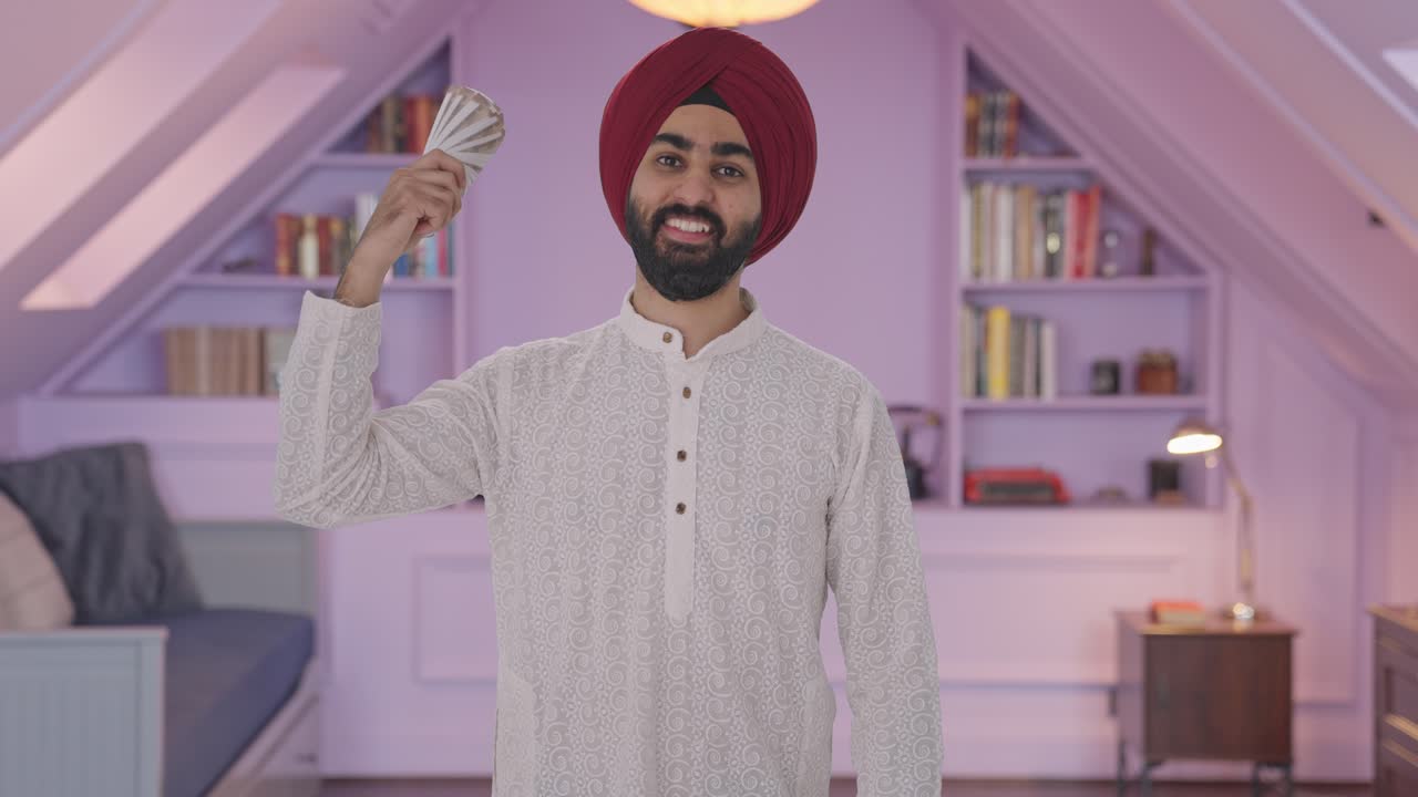 Felice uomo Sikh indiano che si sventola con i soldi.