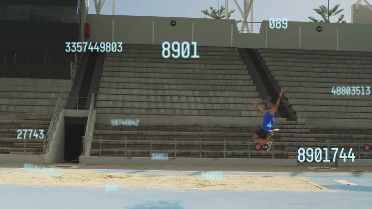 Atleta di atletica leggera che entra nella corsia blu di destra tentando il salto in lungo, mentre numeri si muovono sopra le tribune.