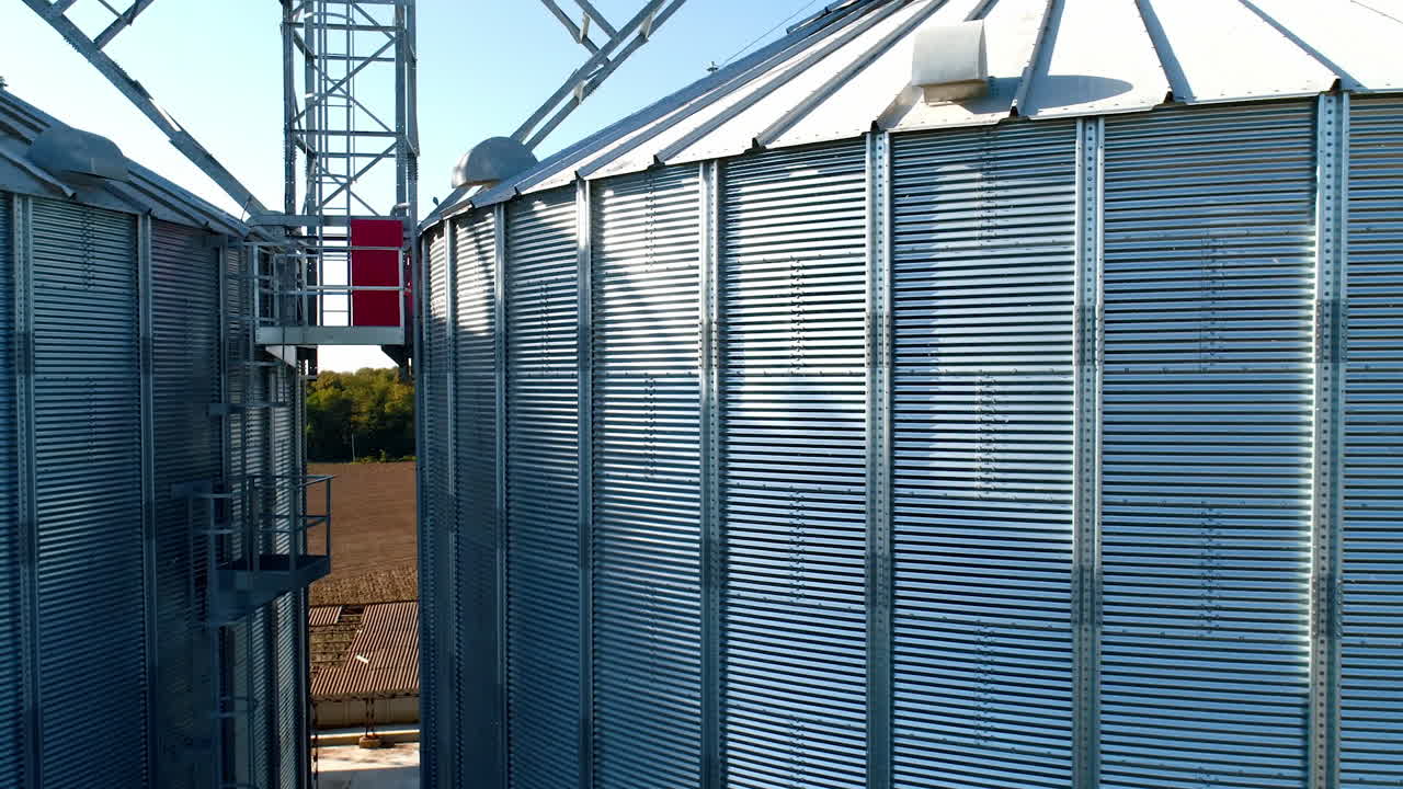 Large storage tanks in nature. Grain terminals. Industrial metal bins for agribusiness. Modern warehouse. Close-up. Aerial view.