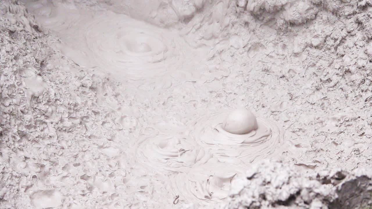 замедленный кадр горячих грязевых бассейнов, бурлящих и парных, поднимающихся во время солнечного света - кислотный горячий источник в природе