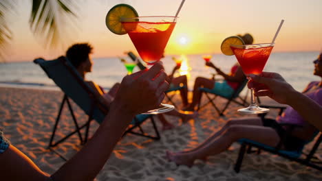 friends enjoying cocktails at sunset on the beach