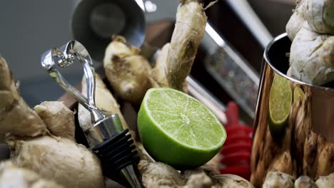 close up zoom in of slice of lime and cluster of ginger root surrounded medicinal spice raw