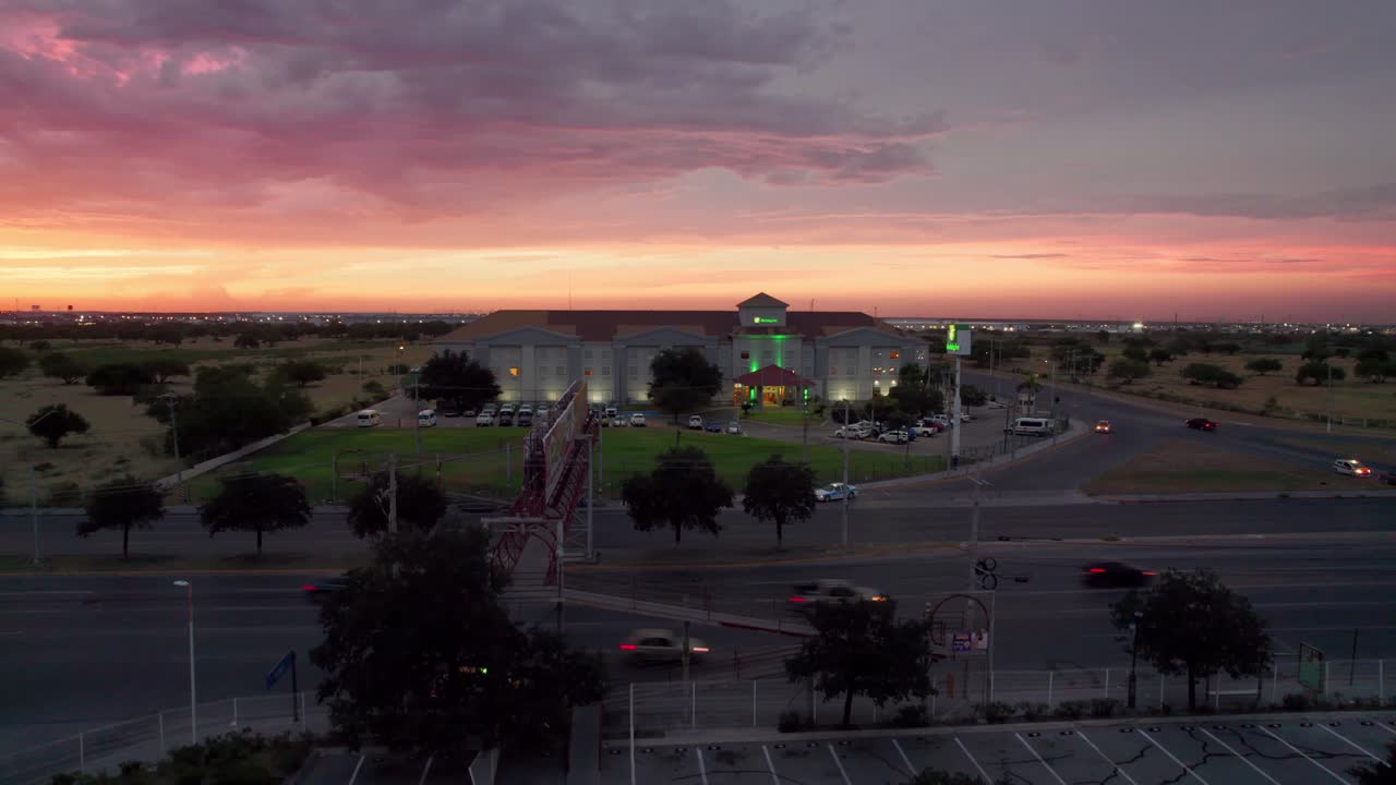 imagen de avión no tripulado de una puesta de sol sobre un bullicioso centro comercial y una concurrida avenida en reynosa, méxico