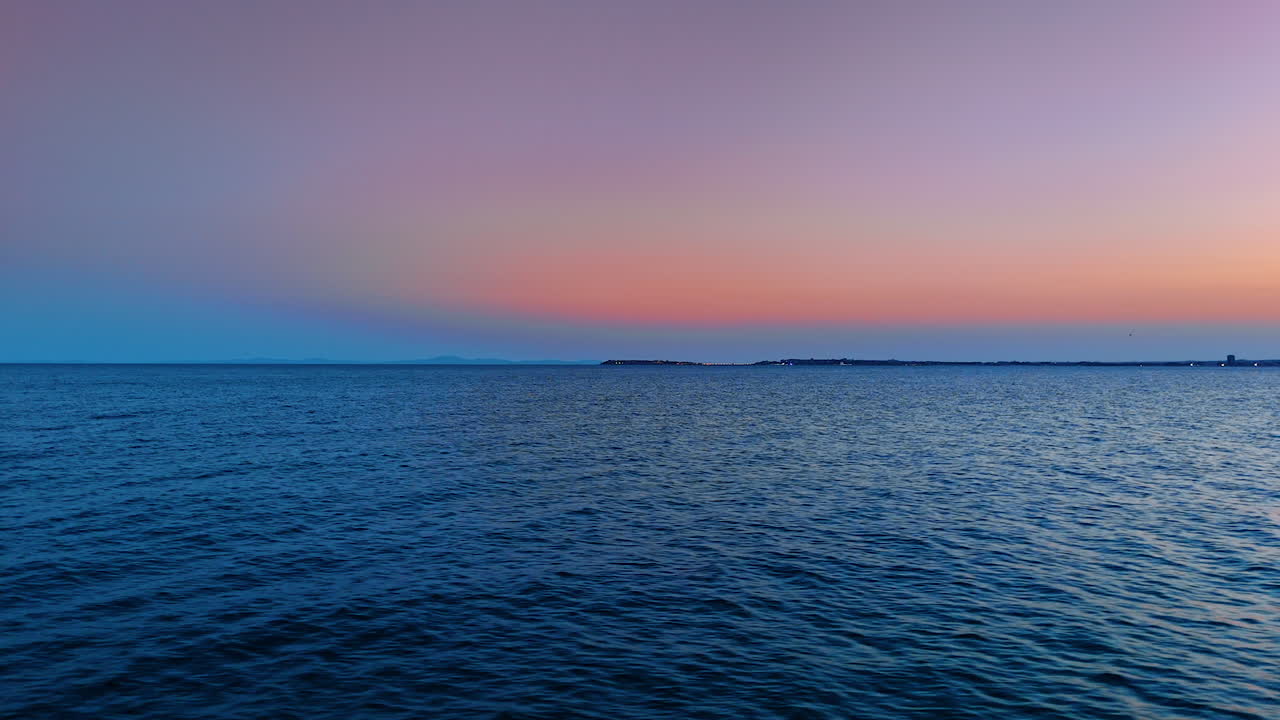 Vibrant sunset over calm ocean waters. A beautiful sunset casts vibrant colors over tranquil ocean waters, creating a serene atmosphere by the shore