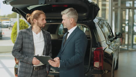 car dealership salesman discussing details with customer