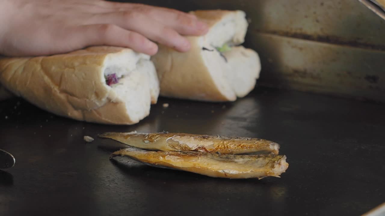 Preparazione di un panino e pesce alla griglia
