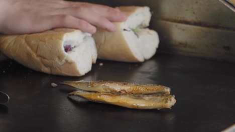 preparing a sandwich and grilled fish