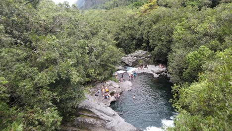 Drohnenaufnahmen,-Die-Einem-Fluss-Mit-Schwimmenden-Menschen-Auf-Der-Insel-La-Réunion-Folgen