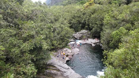 imágenes de drones siguiendo un río con personas nadando en la isla de la reunión