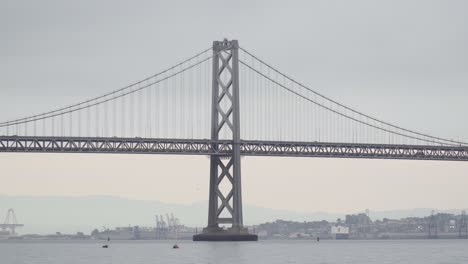 tráfico y automóviles que cruzan el puente de la bahía de san francisco de oakland en una mañana sombría