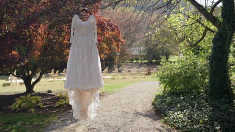 wedding dress hangin in tree before wedding still shot serene