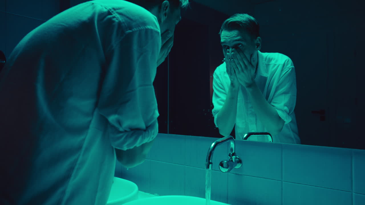 A man in a bathroom reflecting on himself