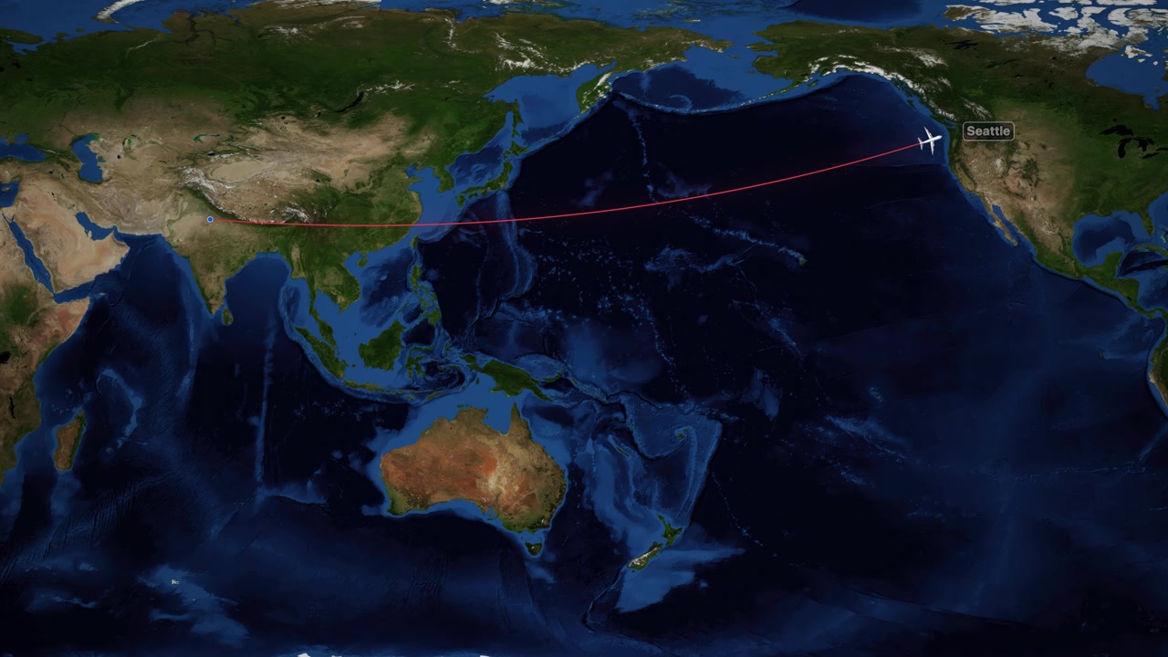 A red line tracks an airplane flying across a world map from Delhi to Seattle