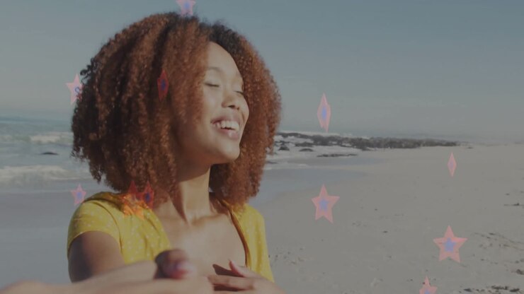 Woman spinning on sandy beach following operator handhold, showcasing marketing with pink stars