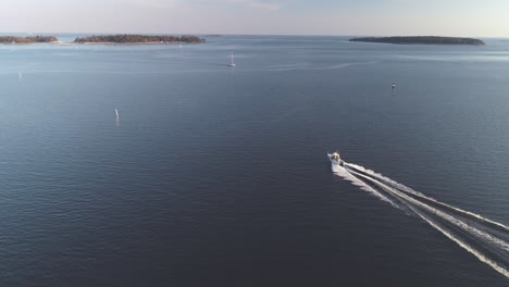 Breite-Tracking-Luftaufnahme-Eines-Motorboots,-Das-Aufs-Meer-Hinausfährt