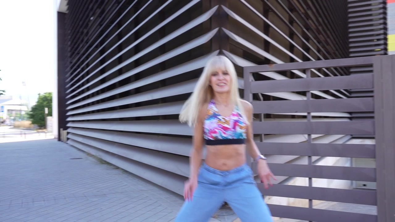 Ballando energicamente in una location urbana elegante con un outfit alla moda che irradia energia vibrante.