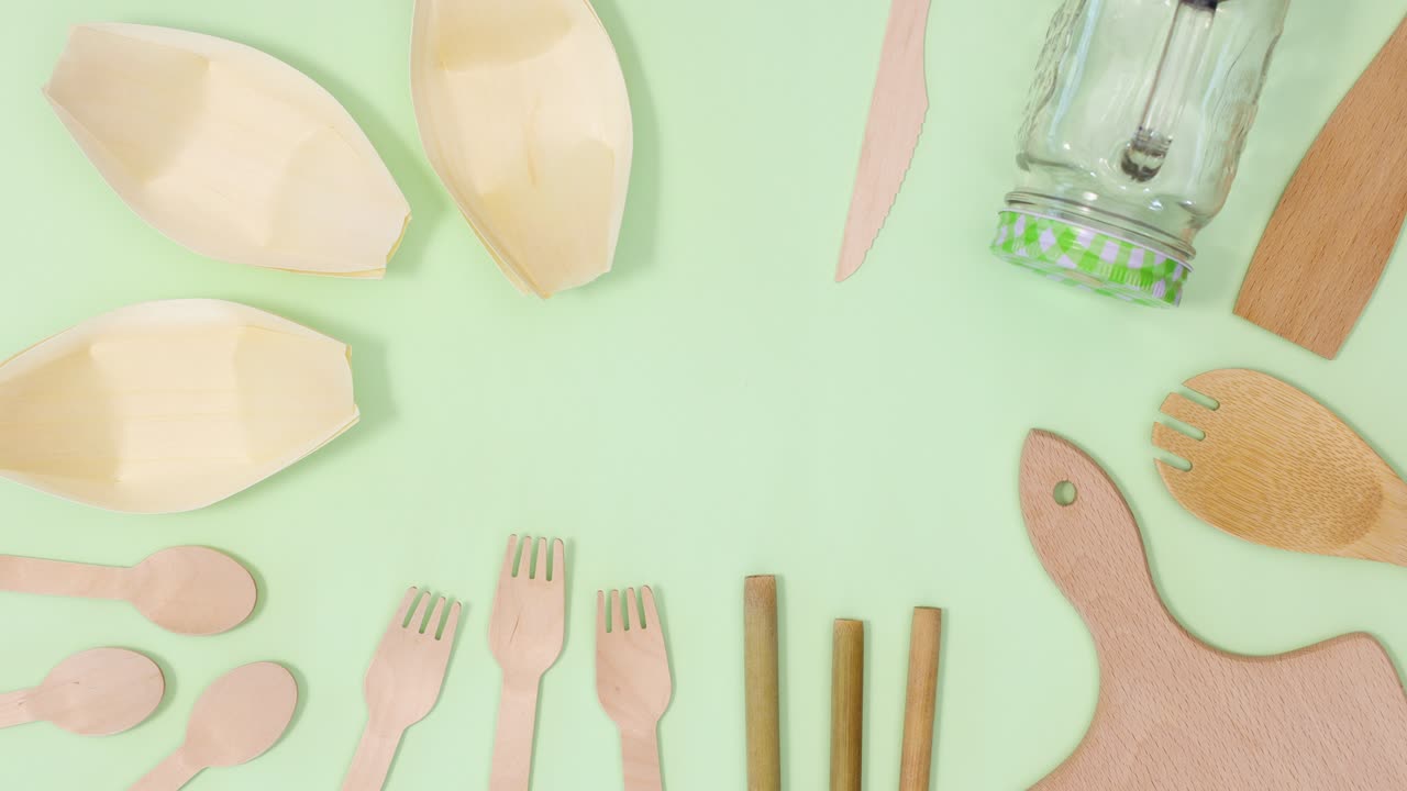 친환경 제로 폐기물 대나무 주방 용품은 밝은 녹색 배경에 프레임을 만니다.