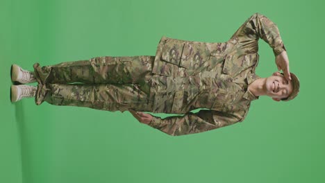 full body of asian man soldier saluting and smiling while standing in the green screen background studio
