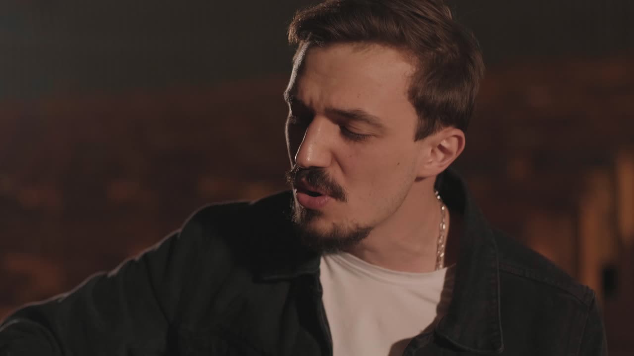 한 남자 한 명이 버려진 영화관에서 어쿠스틱 기타를 연주합니다. 음악가는 노래를 부르고 기타로 동행합니다.