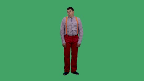 불만을 품은 남자는 머리를 흔들고 눈을 휘두르며 녹색 스크린의 스튜디오에서 오렌지색 서펜서와 함께 카레드 셔츠를 입은 안경을 입은 남자의 초상화.