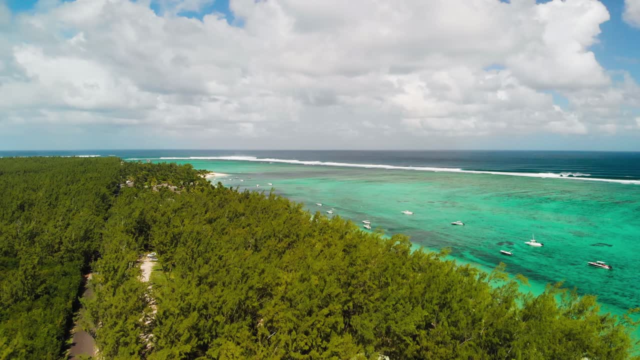인도양의 수정처럼 맑은 청록색 물에 여전히 보트가 있는 르 몬 해변