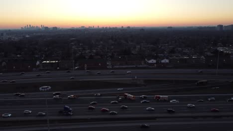 Car-crash-site-on-a-busy-highway,-with-police-and-firefighters-vehicles-with-siren-lights-on,-at-sunset