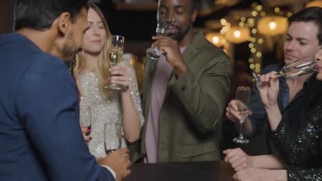 Tracking-Shot-Approaching-Group-of-Friends-Talking-and-Drinking-In-a-Bar