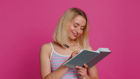 woman making notes writing down thoughts with pen into notepad notebook diary to do list good idea