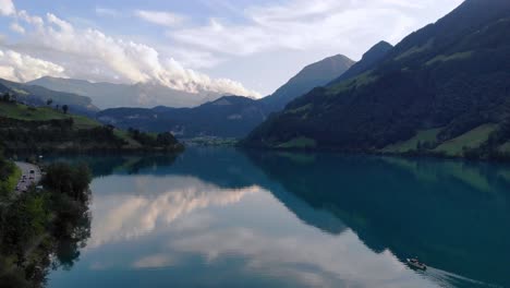 fishing boat on serene lungernersee lake in swiss alps mountains,aerial panorama