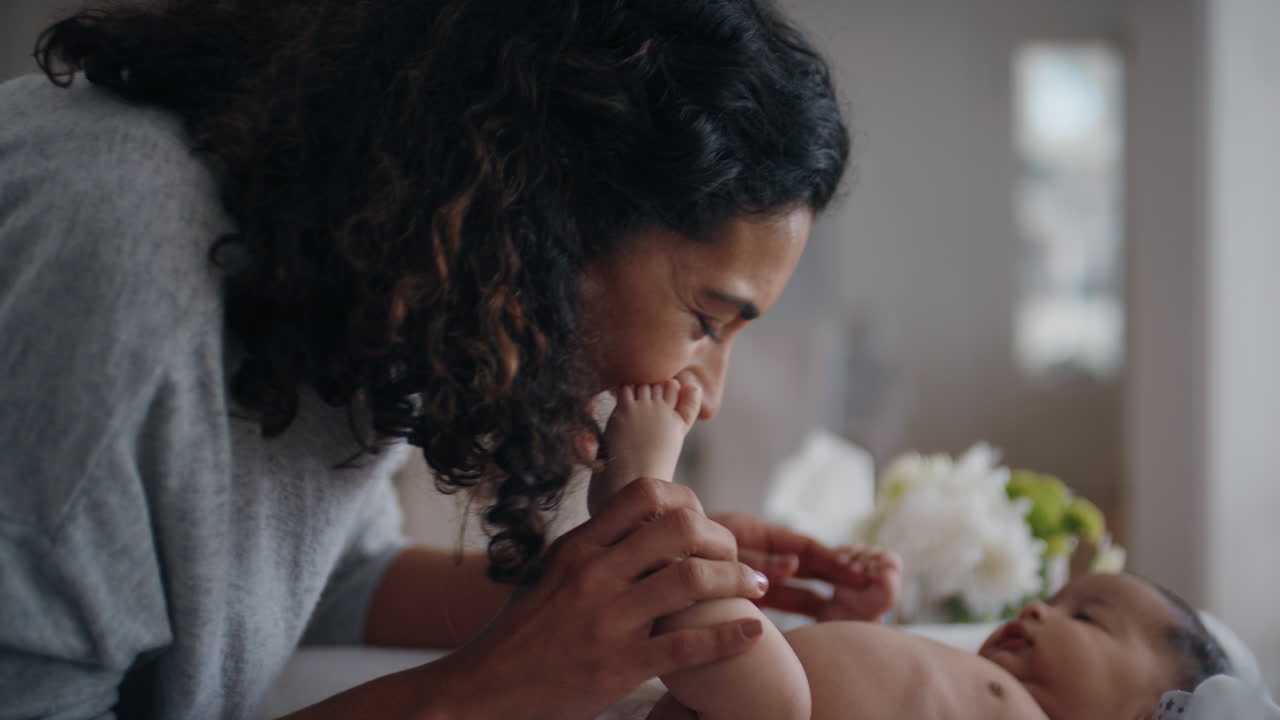 mother caring for baby on changing table happy mom playfully soothing toddler nurturing her child at home 4k footage