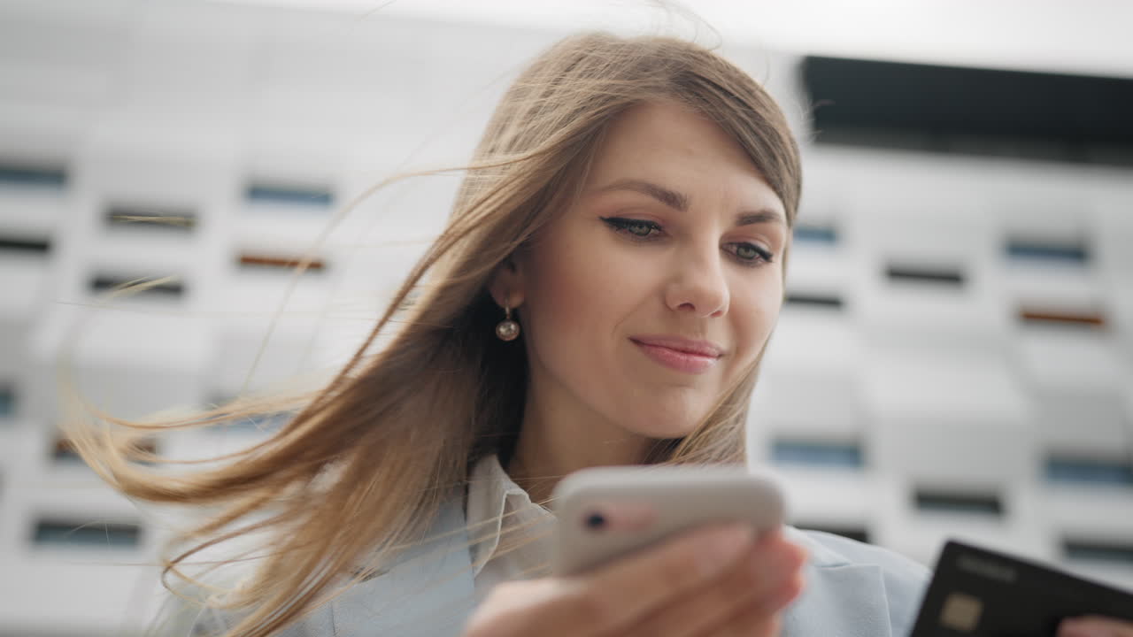 Donna attraente che inserisce il numero della carta di credito per lo shopping online usando lo smartphone.
