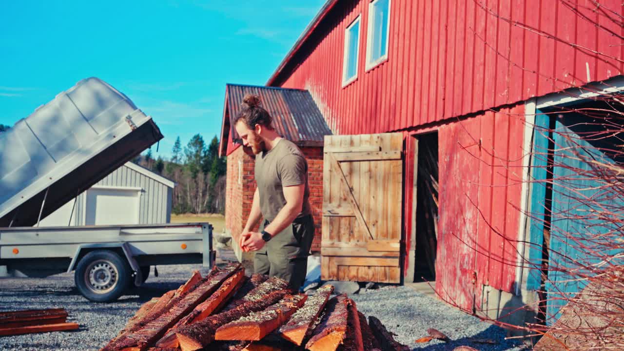 A Man is Taking Fresh Logs Off the Truck - Static Shot