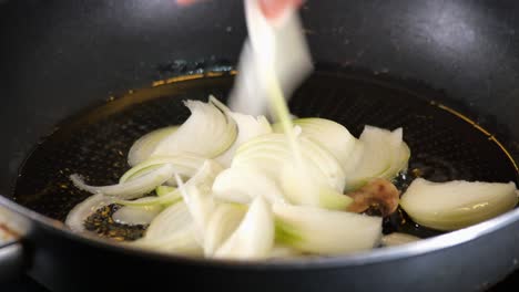 sliced onions frying in a pan