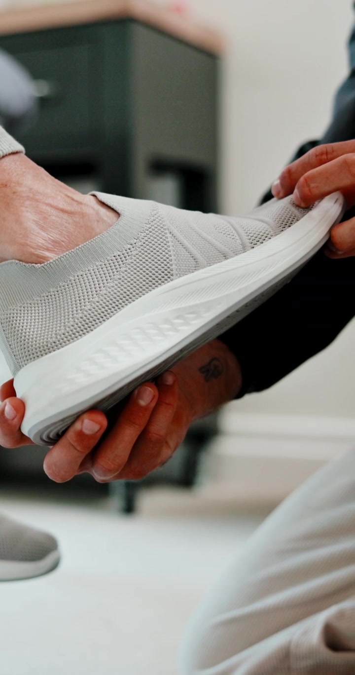 Person Assisting Senior with Putting on Comfortable Slip-on Shoes