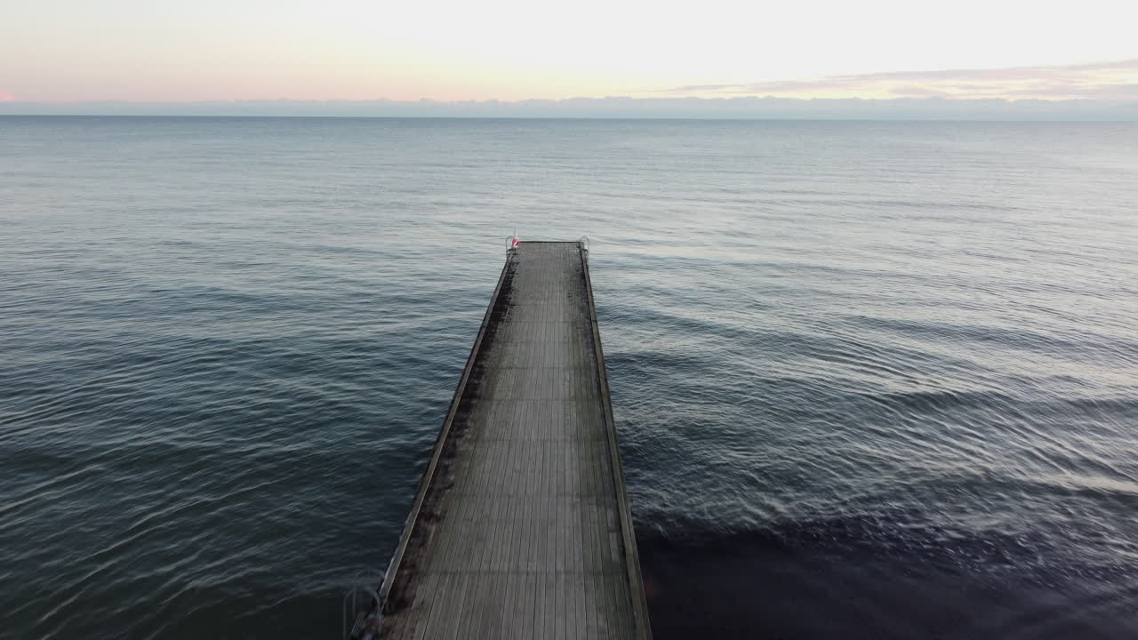 puente de baño junto al agua con salida del sol