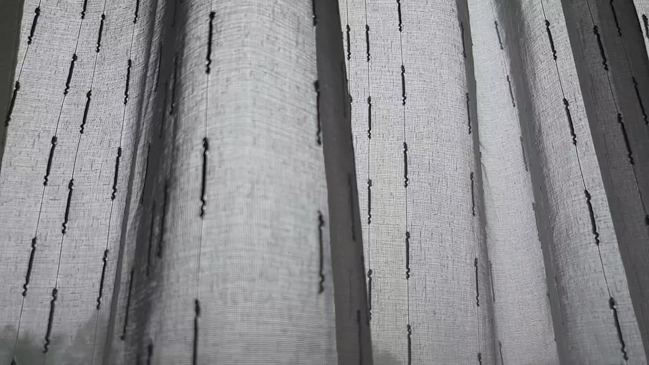 miserables y solitarias cortinas de día lluvioso moviéndose lentamente mientras el viento frío sopla a través de la ventana