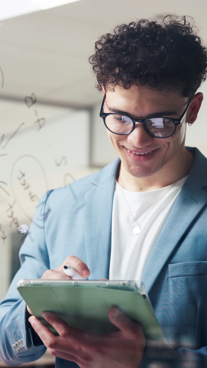 Homem jovem com cabelo cacheado escrevendo em um tablet digital no escritório