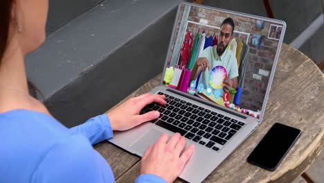 mid section of caucasian woman having a video call with male colleague on laptop