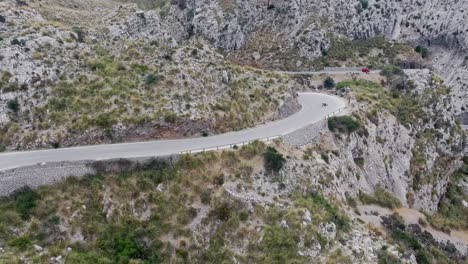 impresionantes imágenes aéreas de 4k de dos personas patinando cuesta abajo en un paisaje épico en mallorca - patinando a través de serpentinas - locos adictos a la adrenalina al aire libre - sa calobra en la serra de tramuntana