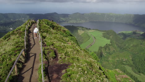 woman exploring miradouro da grota do inferno, azores with lagoon view